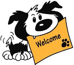 Black and white dog holding a yellow sign that reads welcome